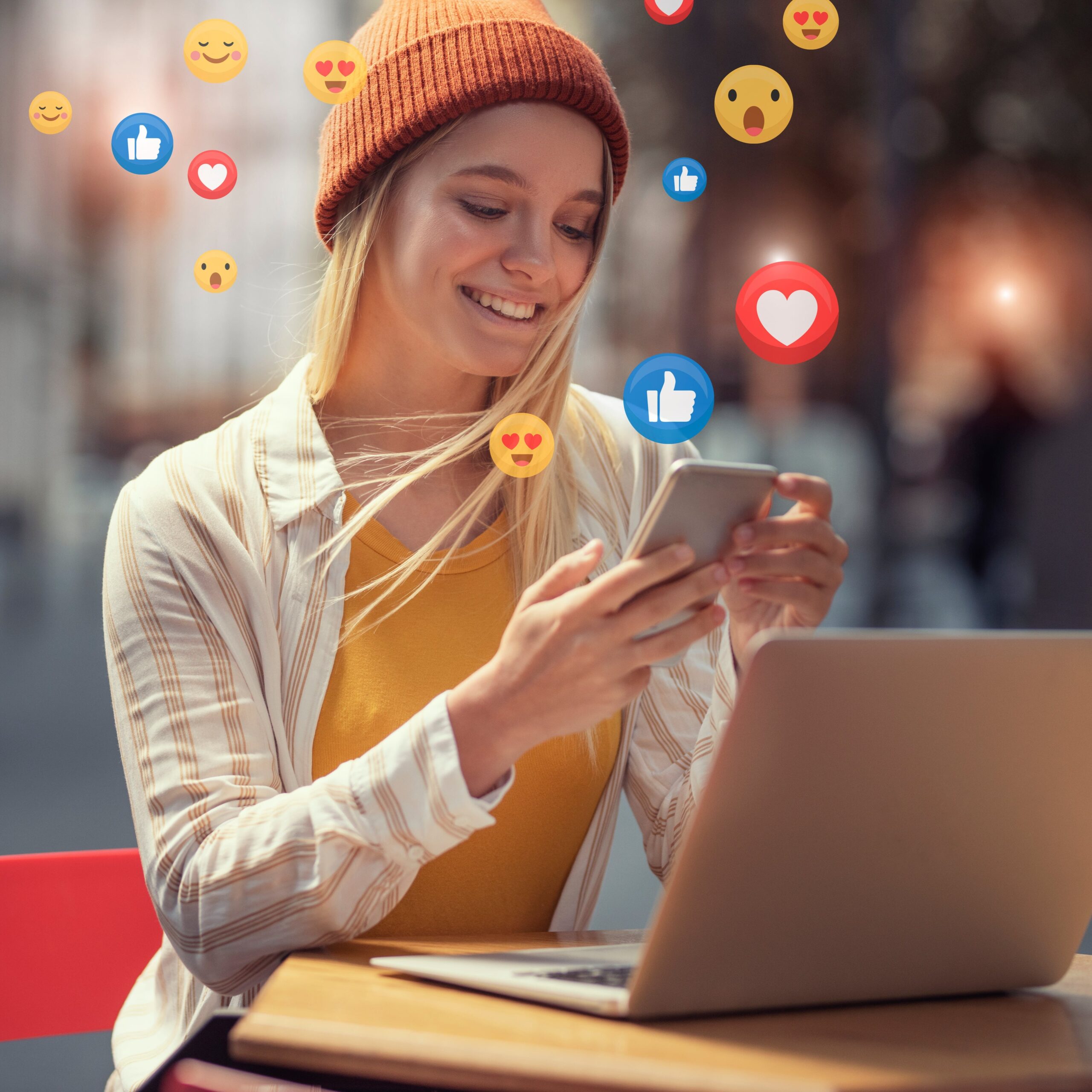 Stock image of a creator using a laptop and phone surrounded by floating social media reaction icons